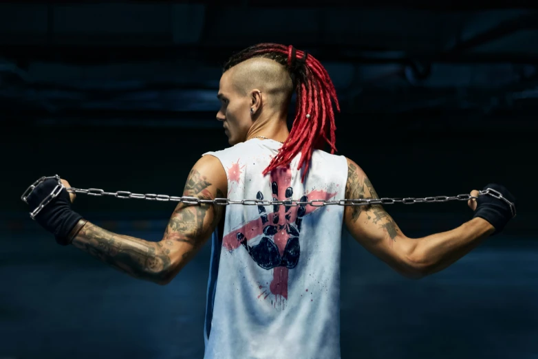 man wearing a chain and a tank top on top of the ground