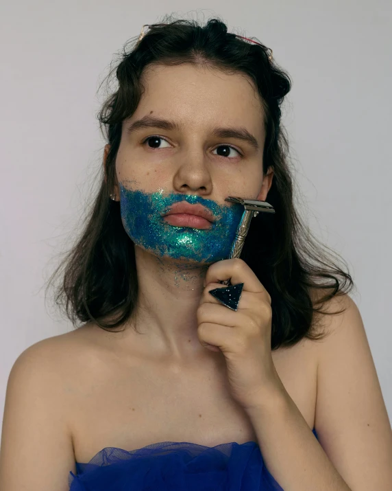 the  is using a blue sponge as an ad for face paint