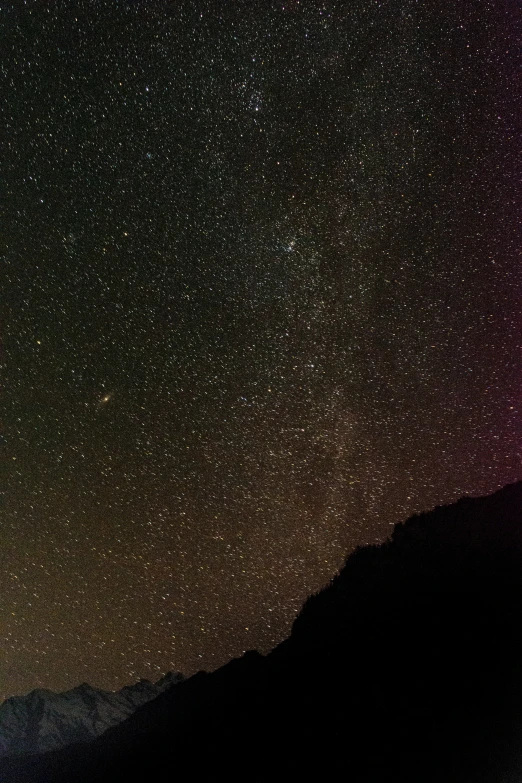 a mountain and night sky covered in stars