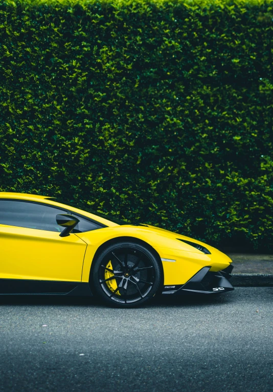 yellow sports car sits parked by the curb