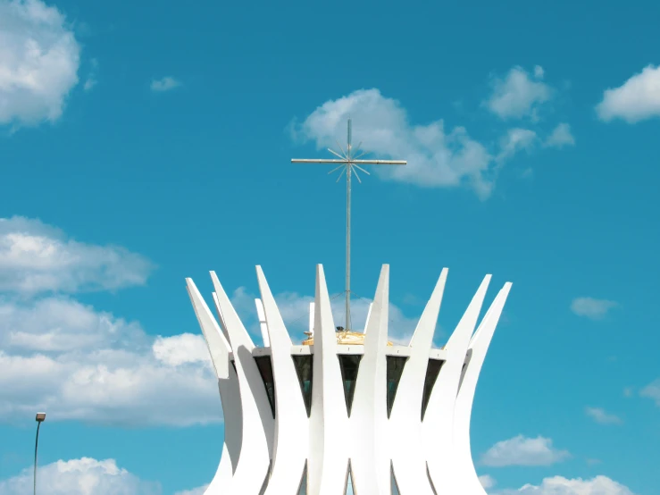 a large white cross sitting on top of a tall tower