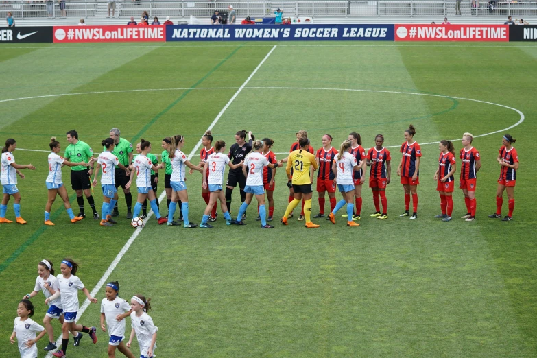 a group of soccer players standing on top of a soccer field