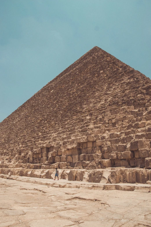 some people are walking in front of a large brick pyramid