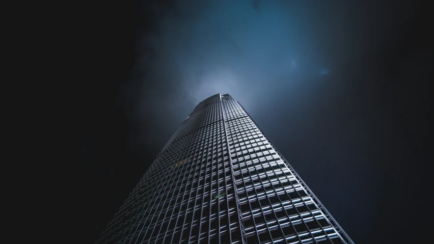 a tall building is shown under the dark sky