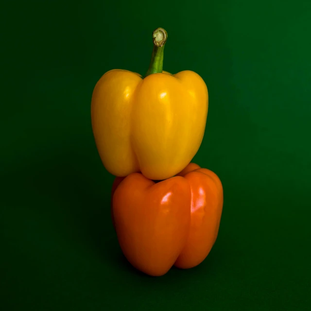 four yellow peppers stacked on top of each other