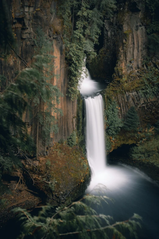 the water is running over the rocky cliff and down to the waterfall