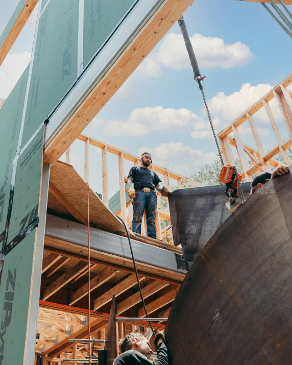 three men on the roof of a house under construction