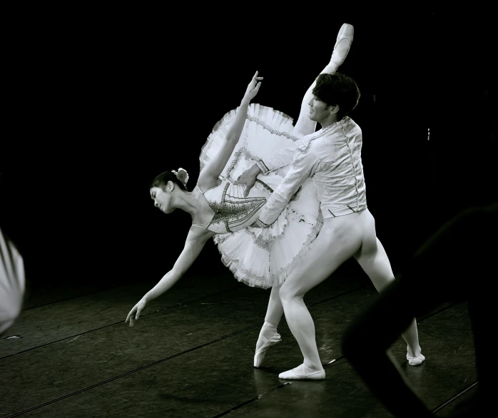 two people on stage dressed in ballet clothes