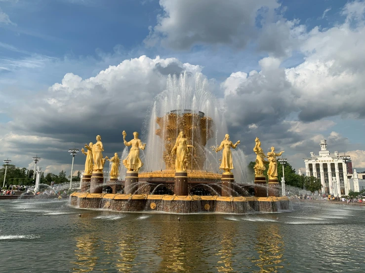 the fountain in the park has two yellow figures on it