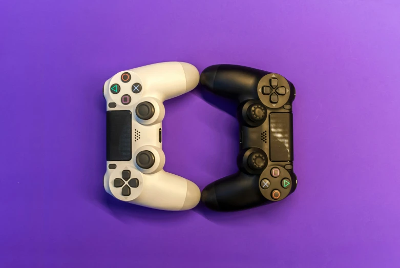 two game controllers next to each other on a purple background