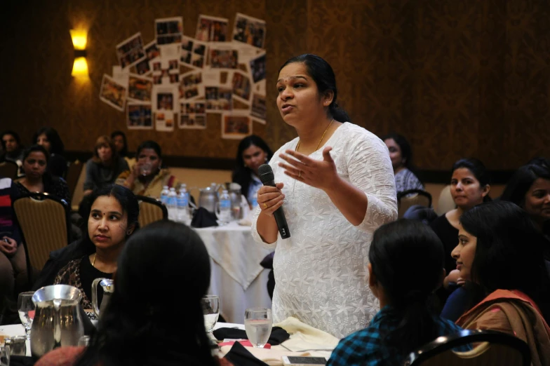 woman speaking in front of an audience at a conference