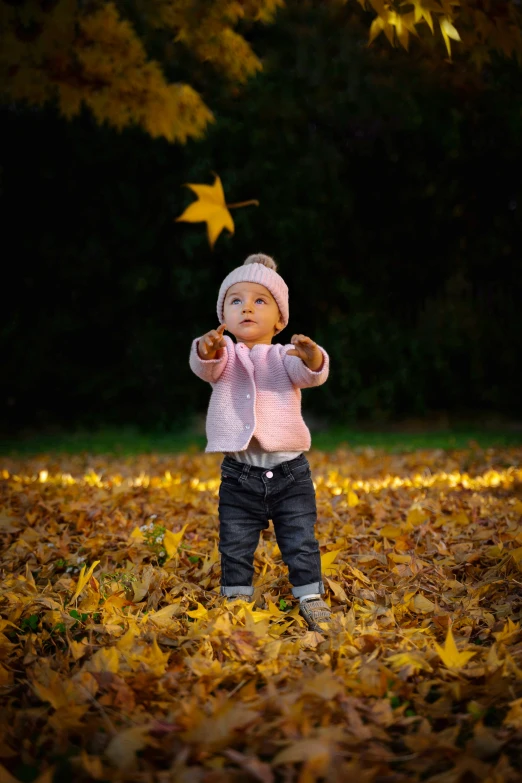 little girl wearing a knit hat and throwing a star to the air