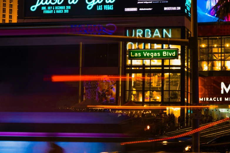 the lights on the city street illuminate neon signs