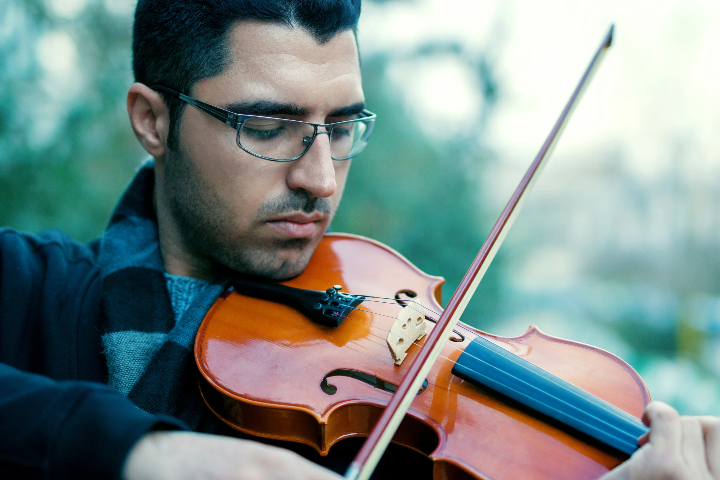 a man playing the violin on a sunny day