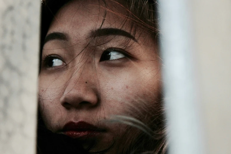 a woman making a face from behind the window