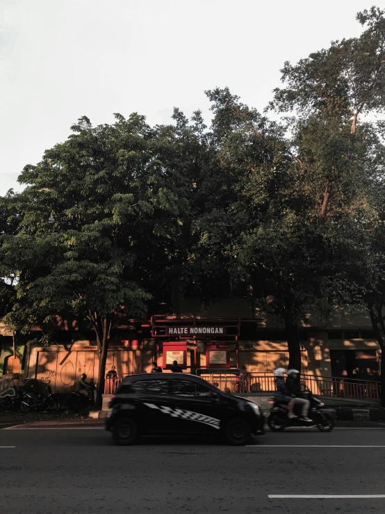 several cars parked in front of a building next to some trees