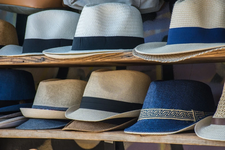 several rows of hats sitting on a shelf