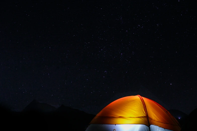 a red and white tent with mountains in the background