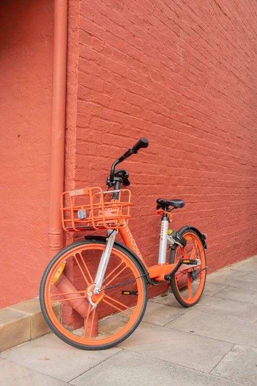 a bike that is parked next to a red wall