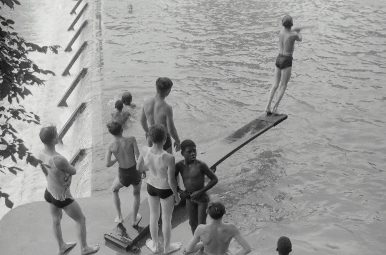 a group of men standing next to each other in front of a body of water