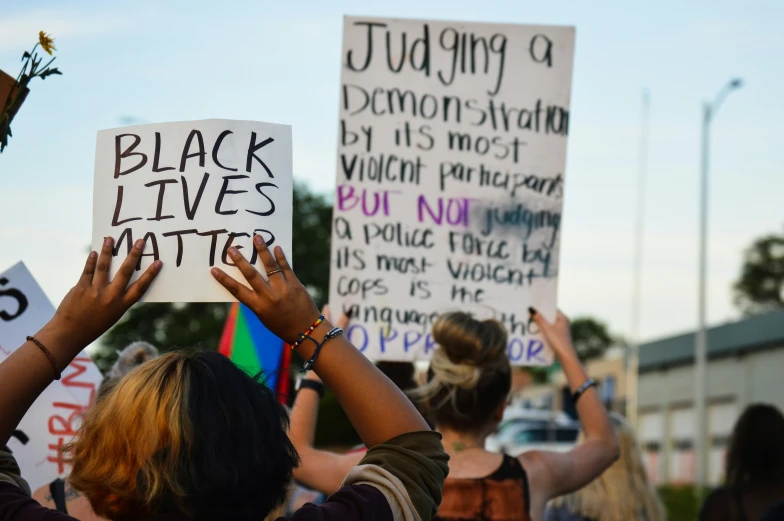 people hold signs with words that read, judging black lives matter