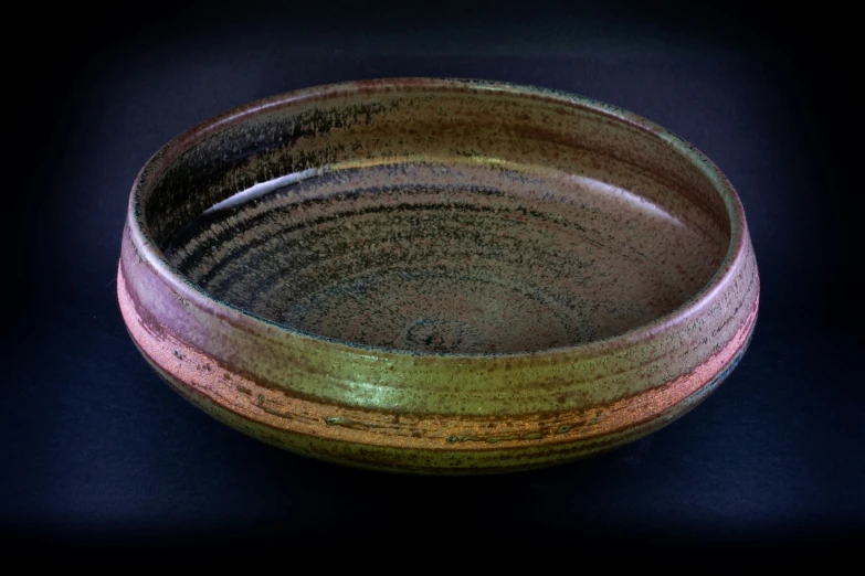 a bowl on a black surface with some designs