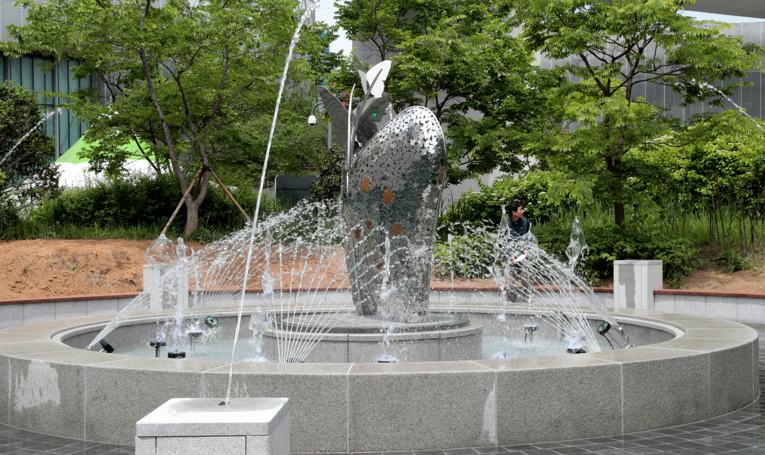 a fountain surrounded by trees in a courtyard