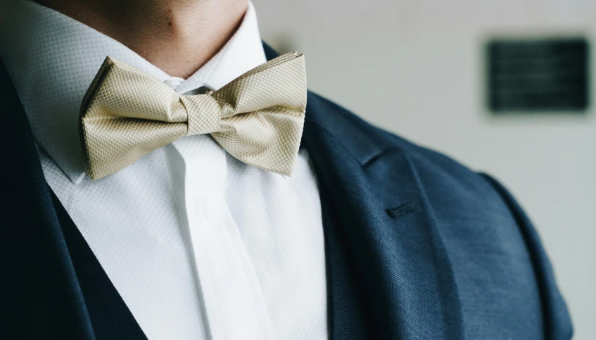 a man wearing a jacket, bow tie and black jacket