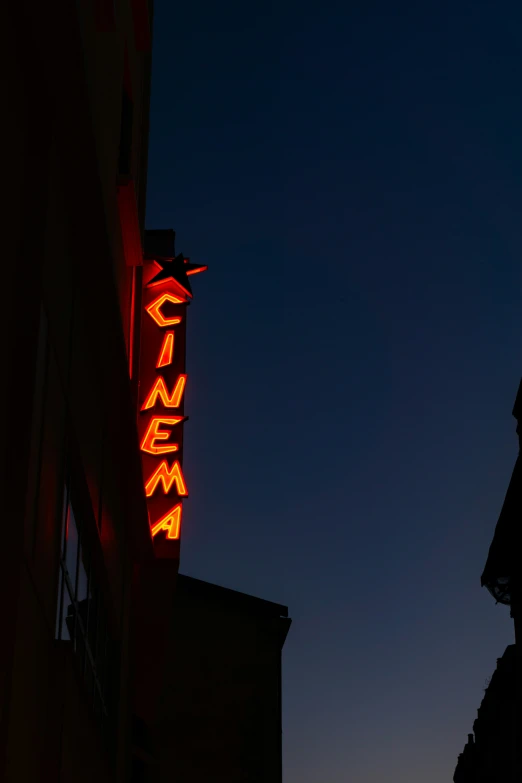 a building with a lit up sign hanging off it's side