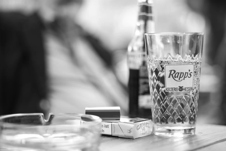 a glass and some dices sitting on a table