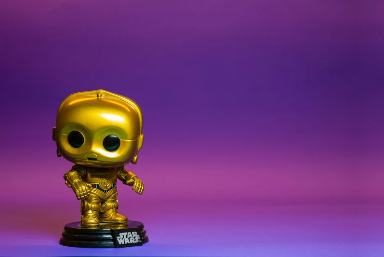 the golden robot is on a purple and pink background