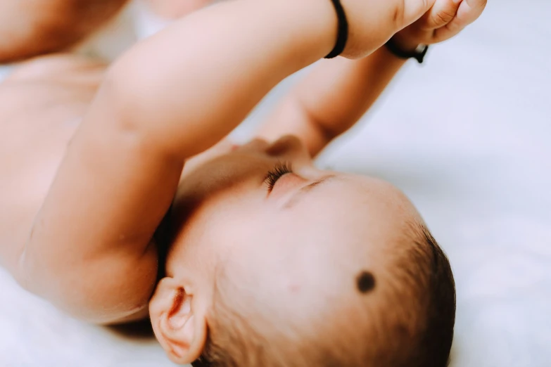 there is a baby that is taking a selfie with its head on her arm