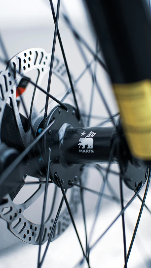 the front wheel of a bike with a yellow spoke