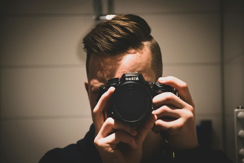 a person taking a picture of a camera in a mirror