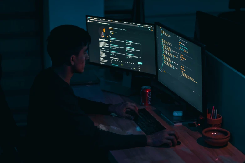 a man working on a computer in the dark
