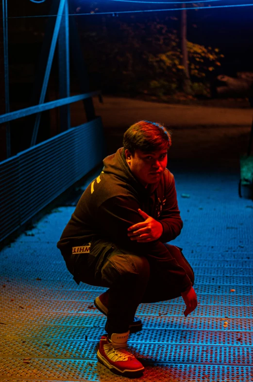 a man squatting on his knees with a blue glow