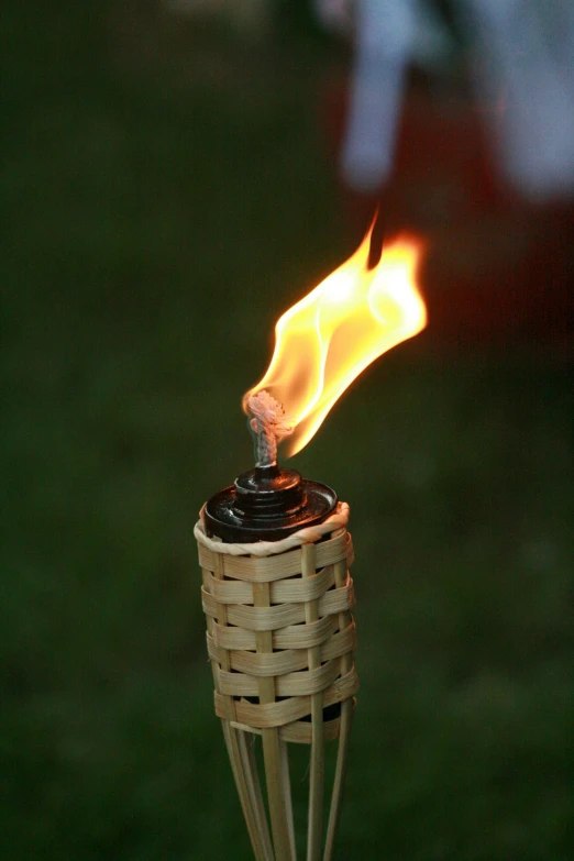 a small fire coming out from a bottle sitting on top of a wooden table