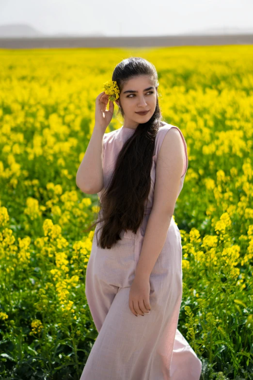  in a field with yellow flowers in her hair