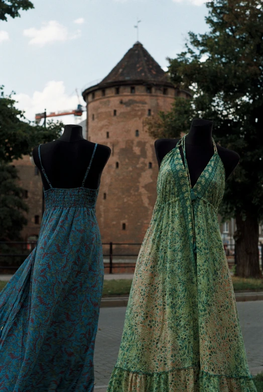 the back and front dresses on display near a building