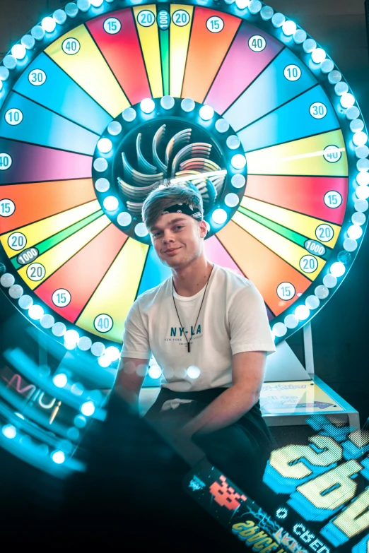 a man sitting in front of a wheel of fortune