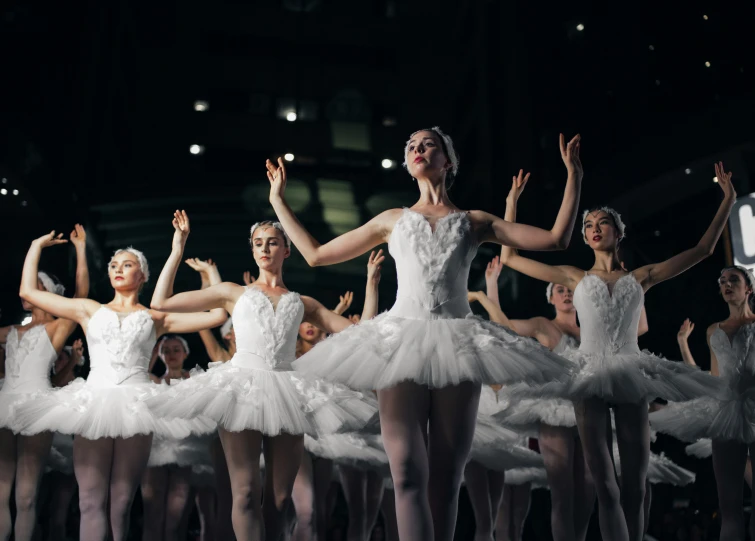a group of ballet dancers are all dressed in white
