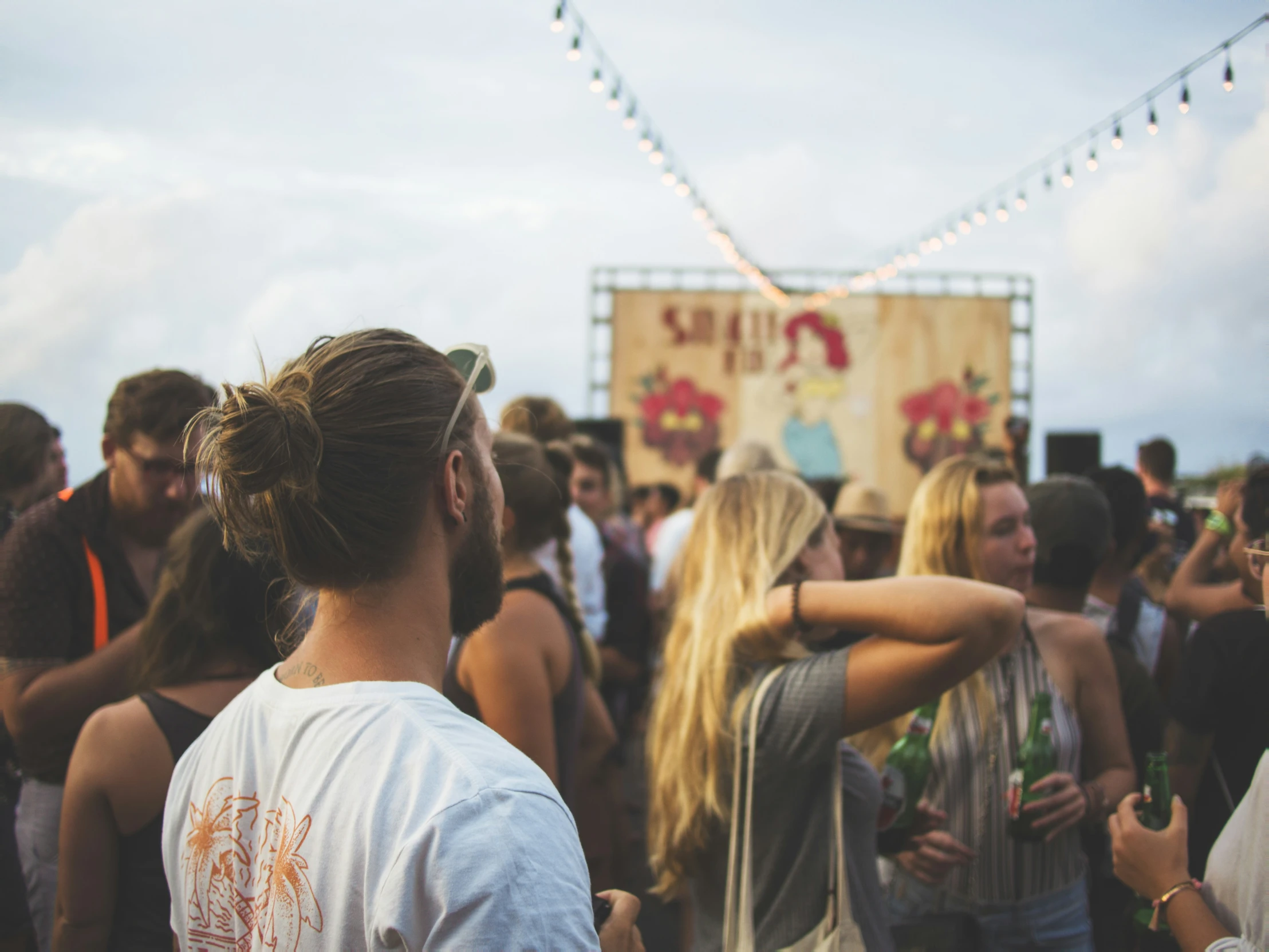 people dance with a big sign in the background