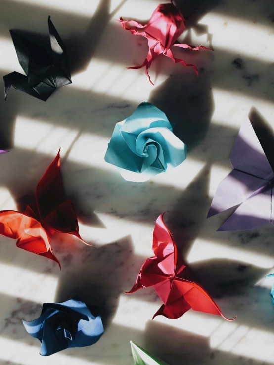 a number of colorful origami flowers laying on a table