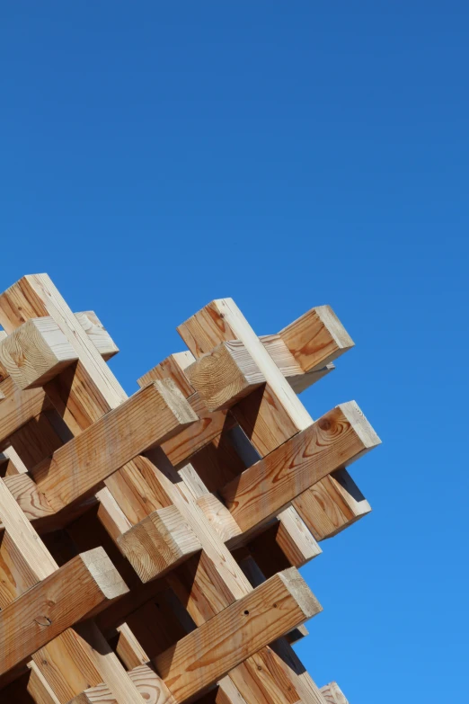 a wooden sculpture is against the blue sky