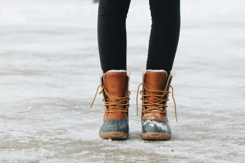 a person is wearing well worn boots in the snow