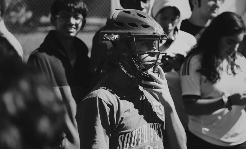 the young man is wearing a helmet with people watching him