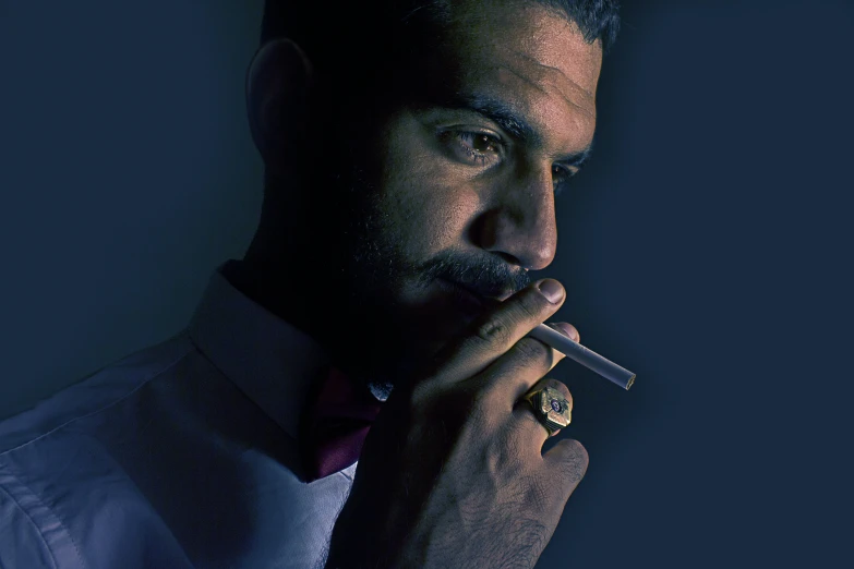 man in vest and bow tie holding cigar in hands