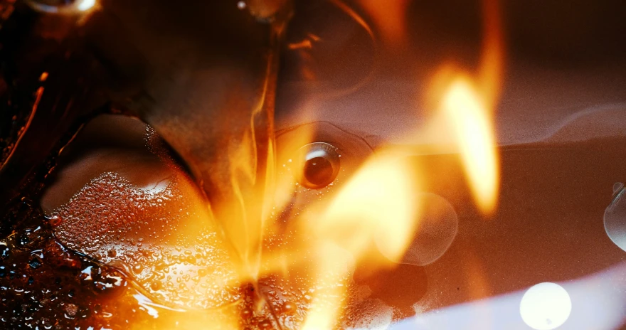 a burning piece of metal is overlayed in small flames