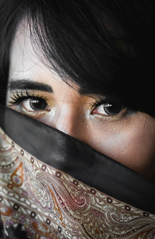 a woman with her eyes open wearing a veil