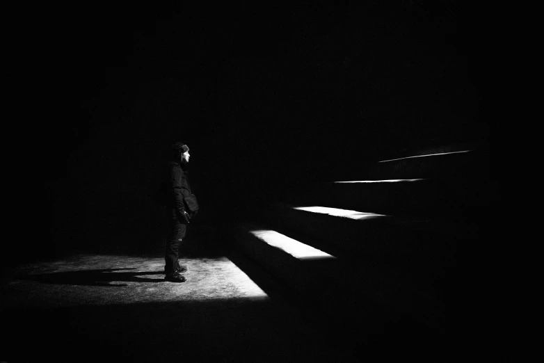 a man standing in the dark on stairs